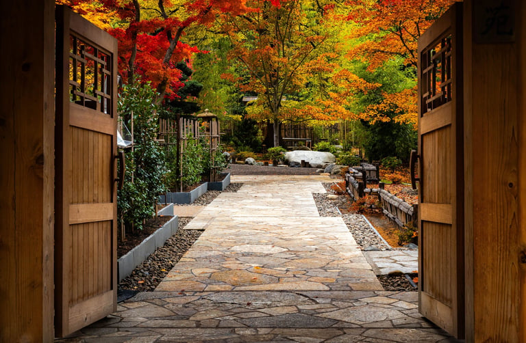 A beautiful view of the entrance to the Japanese Garden framed by vibrant red and yellow trees